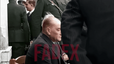 Man In White Shirt In Front Of Red And White Wall With Mustapha Bakni GIF