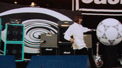 Man In White Shirt Kicking Soccer Ball In Front Of Clash Sign GIF