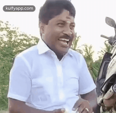 Man In White Shirt Laughing Next To Motorcycle GIF