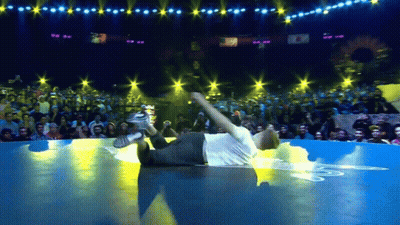 Man In White Shirt Laying On Floor In Front Of Crowd GIF