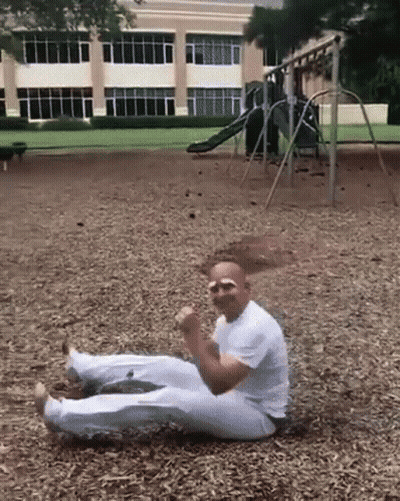 Man In White Shirt Laying On Ground In Park GIF