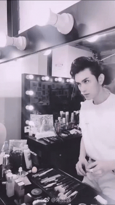 Man In White Shirt Looking At Mirror In Dressing Room GIF
