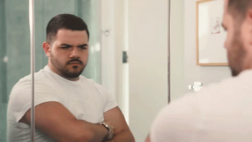 Man In White Shirt Looking At Reflection In Mirror GIF