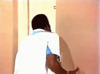 Man In White Shirt Looking Through Door GIF