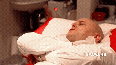 Man In White Shirt Lying In Hospital Bed Arms Crossed GIF