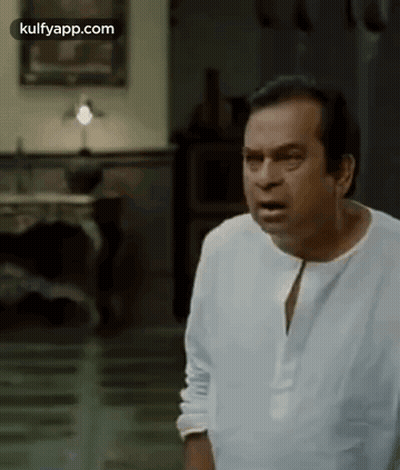 Man In White Shirt Making Funny Face In Living Room GIF