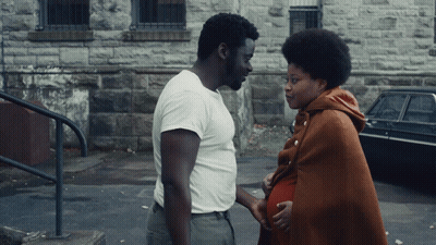 Man In White Shirt Next To Pregnant Woman In Brown Blanket GIF