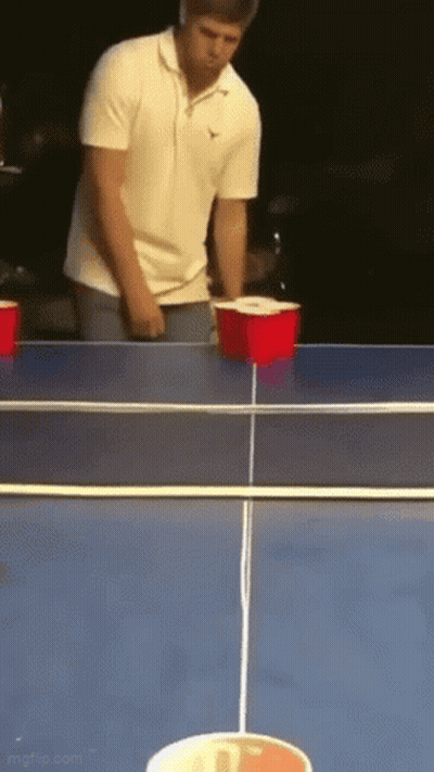 Hombre con camisa blanca jugando beer pong GIF