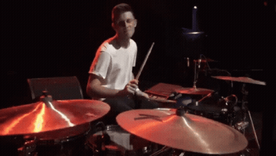 Man In White Shirt Playing Drums In Dark Room GIF