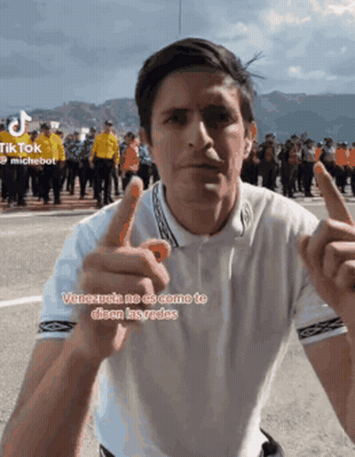 Man In White Shirt Pointing At Camera With Crowd GIF