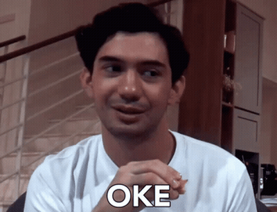 Man In White Shirt Saying Oke In Front Of Stairs GIF