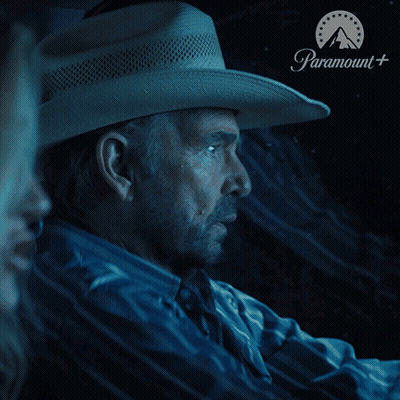 Man In White Shirt Sitting In Front Of Paramount Sign GIF
