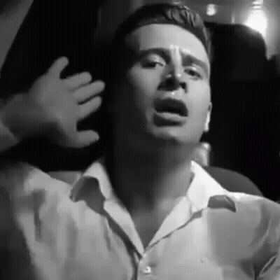 Man In White Shirt Sitting With Hands Outstretched GIF