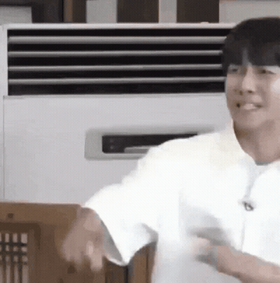 Man In White Shirt Smiling In Front Of Air Conditioner GIF