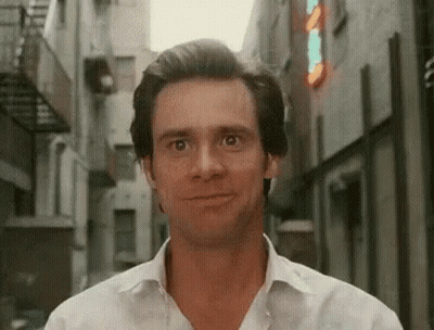 Man In White Shirt Smiling In Narrow Alleyway GIF