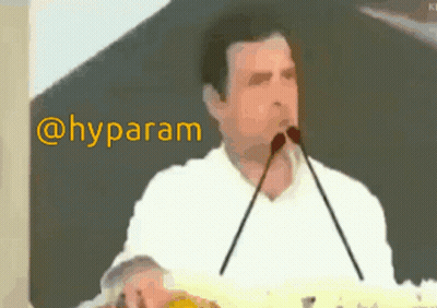 Man In White Shirt Speaking Into Microphone Hyparam GIF
