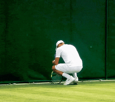 Man In White Shirt Squatting On Tennis Court GIF