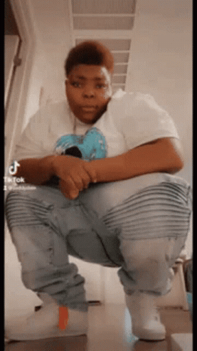 Man In White Shirt Squatting With Legs Crossed GIF