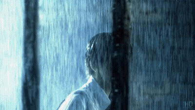 Man In White Shirt Standing Behind Pole In Rain GIF