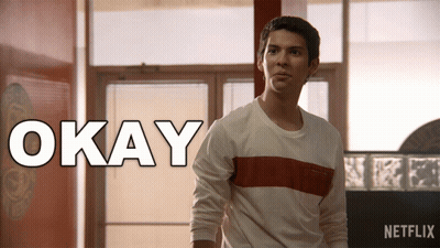 Man In White Shirt Standing In Front Of Okay Sign GIF