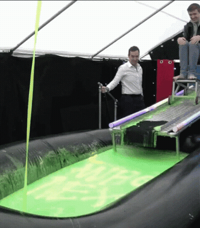 Man In White Shirt Standing In Green Liquid With Yellow Ribbon GIF