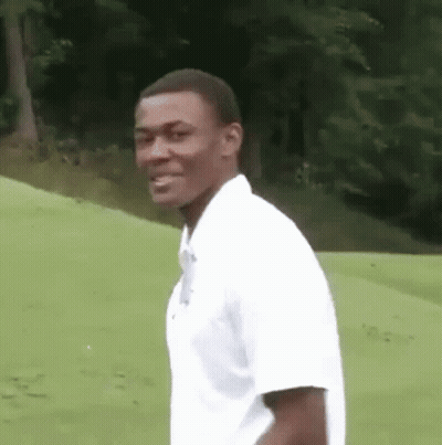 Man In White Shirt Standing On Green Field GIF