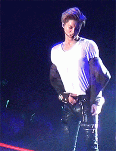 Man In White Shirt Standing On Stage Holding Microphone GIF