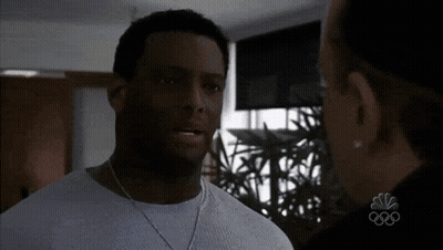 Man In White Shirt Talking To Woman With NBC Logo GIF