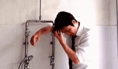 Man In White Shirt Tie Leaning On Pipes GIF