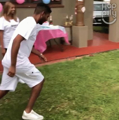 Man In White Shirt Walking On Lush Green Lawn GIF