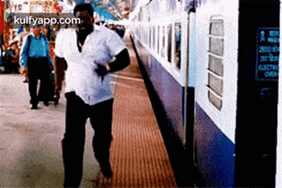 Man In White Shirt Walking Towards Train GIF