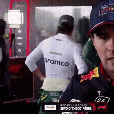 Man In White Shirt With Aramco On Back In Front Of Mirror GIF