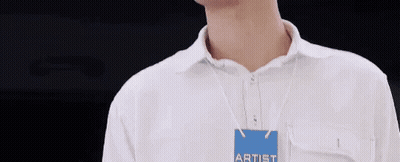 Man in White Shirt With Artist Name Tag