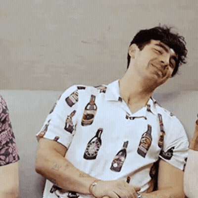 Man In White Shirt With Bottles Sitting On Couch GIF