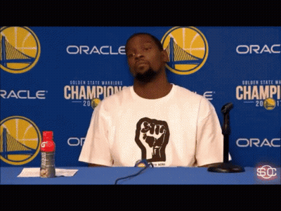 Man In White Shirt With Fist Sitting GIF