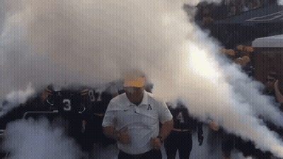 Man In White Shirt With Letter A Walking Through Smoke GIF