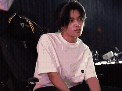 Man In White Shirt With Letter T Sits In Chair GIF
