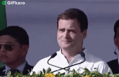 Man In White Shirt With Microphone And Flowers GIF