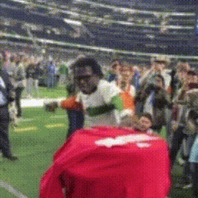 Man In White Shirt With Red Shirt On Back In Field GIF