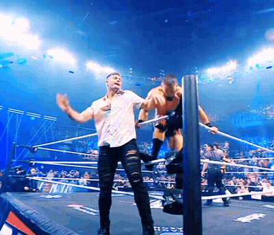 Man In White Shirt Wrestling In Ring Next To Man In Black Jeans GIF