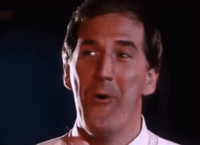 Man In White Singing Funny Face Into Microphone GIF