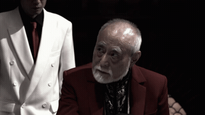 Man In White Suit And Red Tie Next To Man In Red Suit GIF