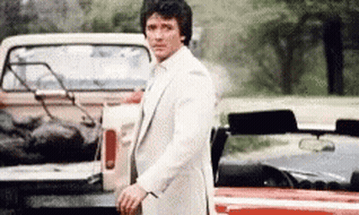Man In White Suit By Truck And Red Car GIF