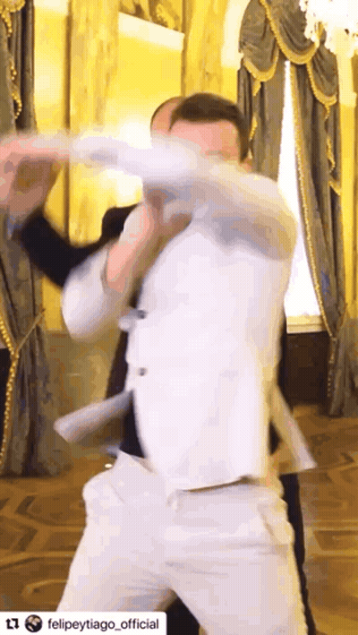 Man In White Suit Dancing In Front Of Window GIF