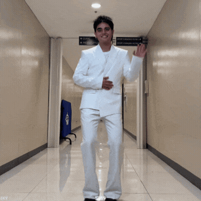 Man In White Suit Dancing In Hallway With GF Sign GIF