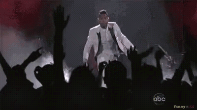 Man In White Suit Dancing On Stage GIF