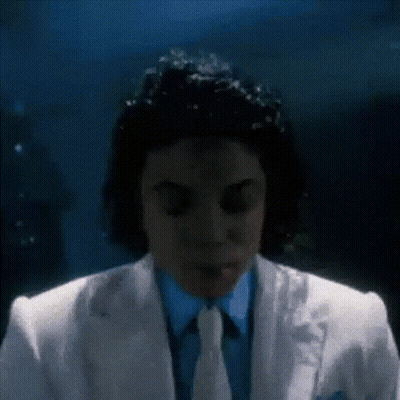 Man In White Suit Eyes Closed In Dark Room GIF