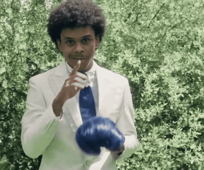 Man In White Suit Holding Blue Glove GIF