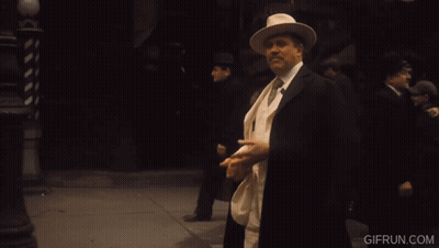 Man In White Suit Holding Orange Cigar Co. Sign GIF