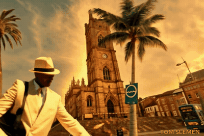 Man In White Suit In Front Of Clock Tower With Palm Tree GIF